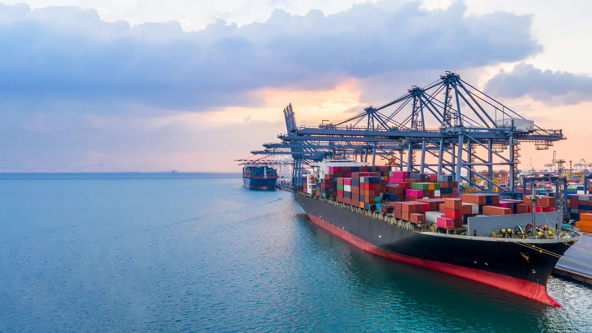 Container ship being loaded by gantry cranes at a container terminal